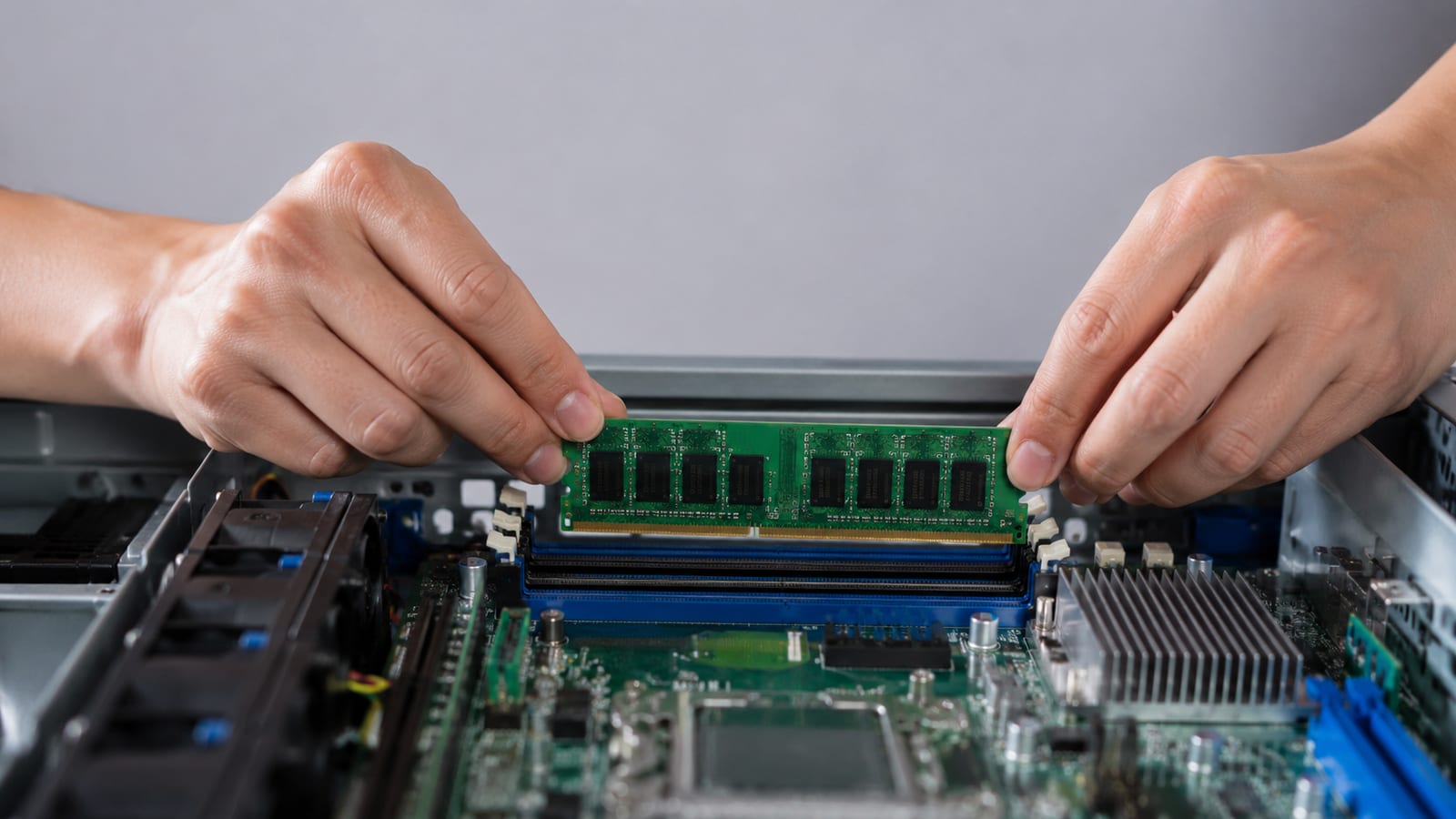 Technician installing ECC memory module into server motherboard slot