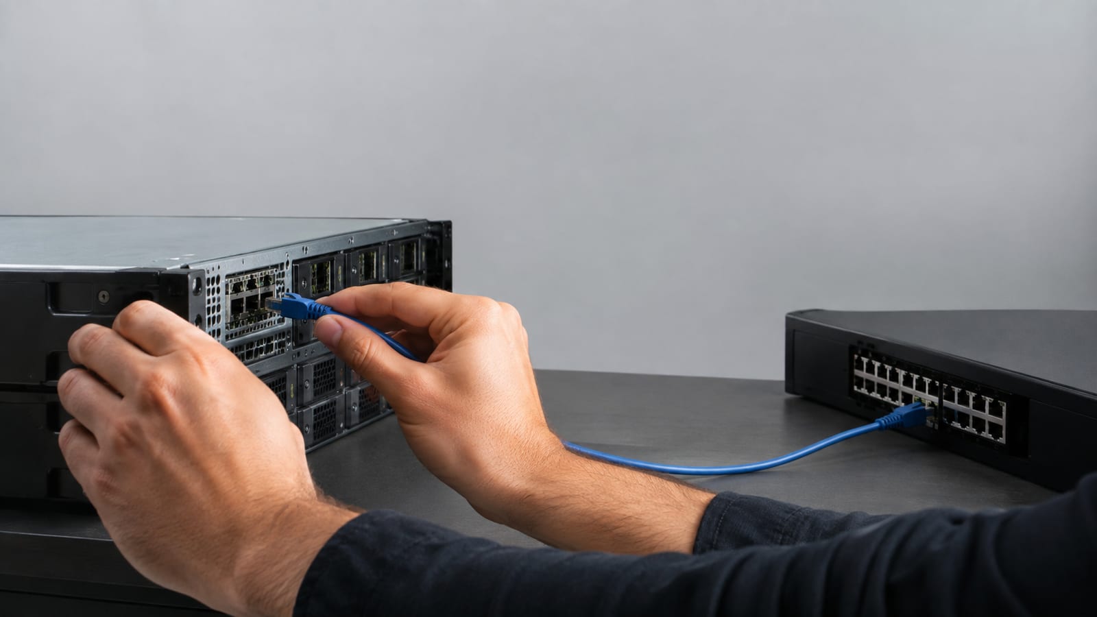 Ethernet cable being carefully moved between server interface ports and network switch