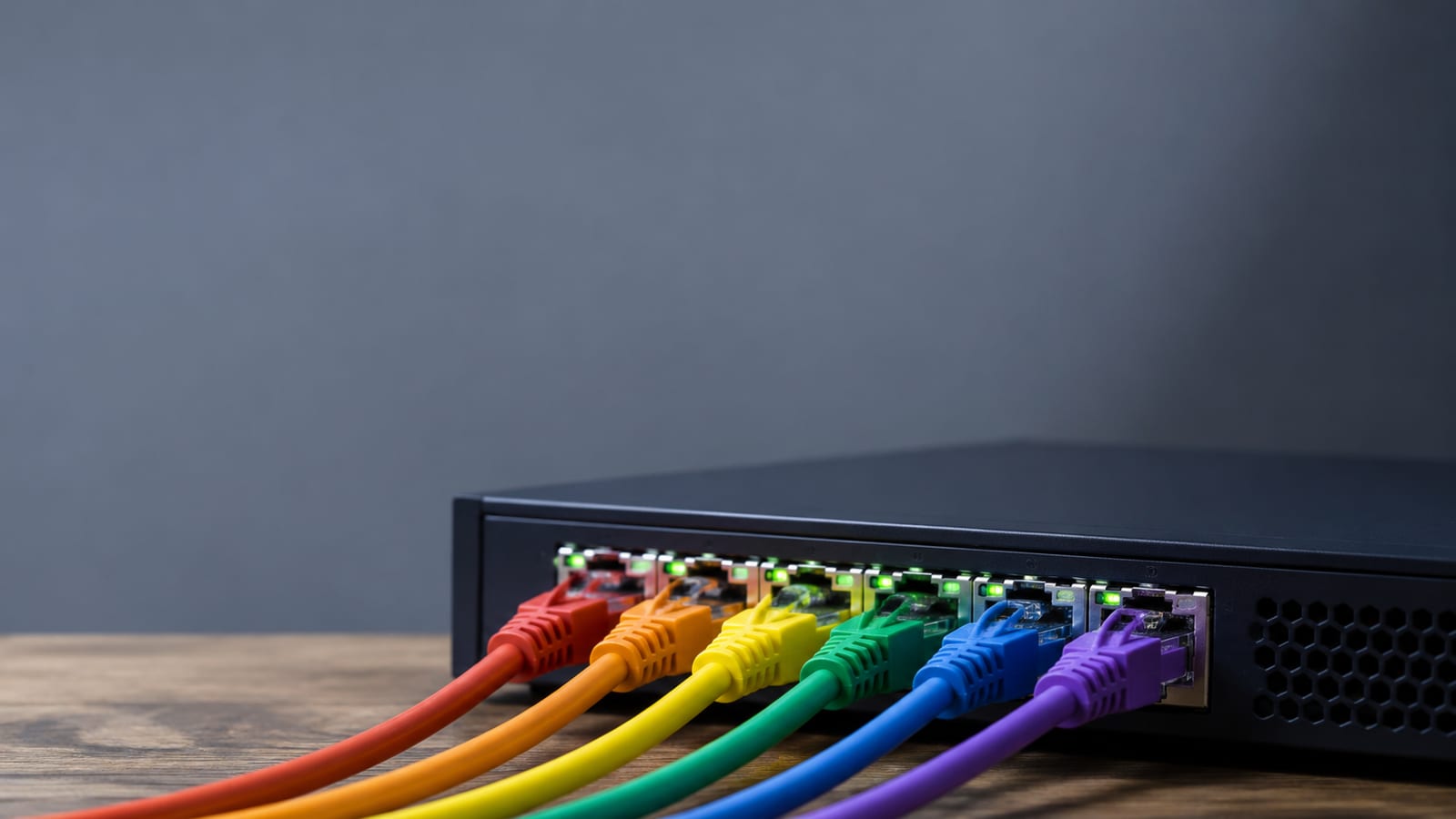 Close-up of Linux server network interfaces and color-coded Ethernet cables beside a switch